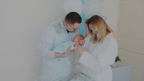 A mãe e o pai felizes apreciam com um bebê recém-nascido no hospital terra arrendada e beijos do pai uma criança parenthood filme A mãe e o pai felizes apreciam com um bebê recém-nascido no hospital terra arrendada e beijos do pai uma criança parenthood filme