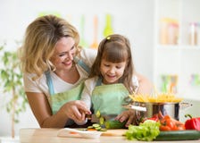 A mãe ensina a filha que cozinha na cozinha imagens de stock A mãe ensina a filha que cozinha na cozinha imagens de stock