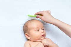 A mãe está escovando o cabelo de seu filho recém-nascido imagens de stock A mãe está escovando o cabelo de seu filho recém-nascido imagens de stock