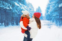 Mãe feliz e criança novas que têm o divertimento fora no inverno Fotos de Stock Mãe feliz e criança novas que têm o divertimento fora no inverno Fotos de Stock