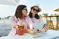 Mãe feliz e filha adolescente que falam e que sorriem Pai com a criança no café exterior do verão que aprecia uma bebida fria em imagens de stock Mãe feliz e filha adolescente que falam e que sorriem Pai com a criança no café exterior do verão que aprecia uma bebida fria em imagens de stock