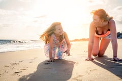 Mãe feliz e filha que têm o divertimento na praia nas férias - mamã que joga com sua criança durante seus feriados fotos de stock Mãe feliz e filha que têm o divertimento na praia nas férias - mamã que joga com sua criança durante seus feriados fotos de stock