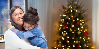 Mãe feliz que abraça sua filha no Natal imagens de stock royalty free Mãe feliz que abraça sua filha no Natal imagens de stock royalty free