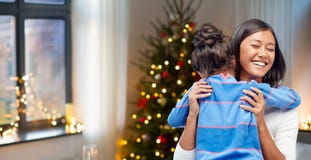 Mãe feliz que abraça sua filha no Natal imagem de stock royalty free Mãe feliz que abraça sua filha no Natal imagem de stock royalty free