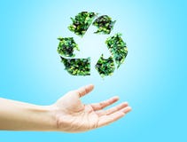 A mão aberta com folha verde recicla o ícone na luz - fundo azul imagem de stock A mão aberta com folha verde recicla o ícone na luz - fundo azul imagem de stock
