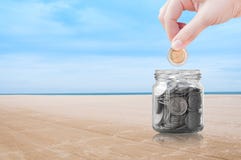 Mão da mulher que põe uma moeda sobre o fundo da natureza da praia, economia, conceito do dinheiro da economia imagem de stock Mão da mulher que põe uma moeda sobre o fundo da natureza da praia, economia, conceito do dinheiro da economia imagem de stock
