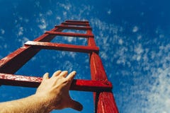 Mão do homem que alcança para a escada vermelha que conduz a um céu azul Conceito do crescimento da carreira da motivação do dese foto de stock Mão do homem que alcança para a escada vermelha que conduz a um céu azul Conceito do crescimento da carreira da motivação do dese foto de stock