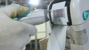 A mão do trabalhador do close up faz a varredura da etiqueta do código de barras na impressora na oficina A mão do trabalhador do close up faz a varredura da etiqueta do código de barras na impressora na oficina