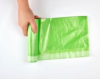 a mão fêmea desenrola o rolo verde com os sacos de plástico para o lixo fotos de stock a mão fêmea desenrola o rolo verde com os sacos de plástico para o lixo fotos de stock