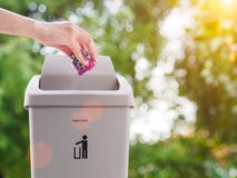Mão fêmea que trowing um papel em um escaninho de lixo no backgrou do bokeh Imagem de Stock Mão fêmea que trowing um papel em um escaninho de lixo no backgrou do bokeh Imagem de Stock