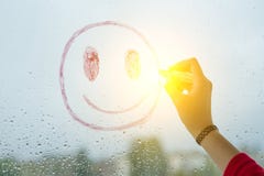 A mão tira o smiley engraçado positivo em uma janela chuvosa do outono imagem de stock royalty free A mão tira o smiley engraçado positivo em uma janela chuvosa do outono imagem de stock royalty free