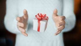 Mãos com a caixa de presente com a fita vermelha para o Natal foto de stock Mãos com a caixa de presente com a fita vermelha para o Natal foto de stock