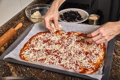 Mãos da mulher que trabalham em uma massa da pizza fotografia de stock Mãos da mulher que trabalham em uma massa da pizza fotografia de stock