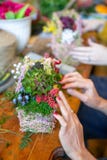 Mãos fêmeas que fazem o ramalhete bonito das flores no fundo imagem de stock Mãos fêmeas que fazem o ramalhete bonito das flores no fundo imagem de stock