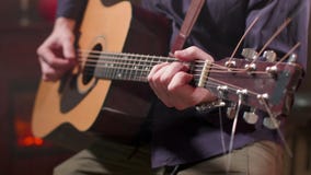 Mãos masculinas que jogam uma música em uma guitarra acústica Mãos masculinas que jogam uma música em uma guitarra acústica