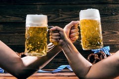 Mãos que guardam canecas de cerveja bávara Oktoberfest imagens de stock Mãos que guardam canecas de cerveja bávara Oktoberfest imagens de stock