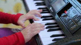 Mädchen, das auf einem Spielzeugklavier, Nahaufnahme spielt stock video Mädchen, das auf einem Spielzeugklavier, Nahaufnahme spielt stock video