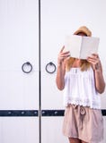 Mädchen, das ein Buch an der Tür liest stockbild Mädchen, das ein Buch an der Tür liest stockbild