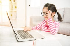 Mädchen, das große Gläser unter Verwendung ihres Laptops trägt Lizenzfreie Stockfotografie Mädchen, das große Gläser unter Verwendung ihres Laptops trägt Lizenzfreie Stockfotografie
