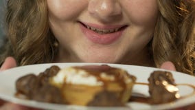 Mädchen, das Lippen an den Bonbons, Schokoladen unter Karamellbelag auf Platte, Nahaufnahme leckt stock footage Mädchen, das Lippen an den Bonbons, Schokoladen unter Karamellbelag auf Platte, Nahaufnahme leckt stock footage