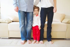 Mädchen, das Mutter und Vati für Beine umarmt lizenzfreie stockfotografie Mädchen, das Mutter und Vati für Beine umarmt lizenzfreie stockfotografie
