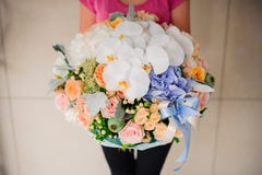 Mädchen, das schönen Mischungsblumenblumenstrauß mit weißer Orchidee hält lizenzfreie stockfotos Mädchen, das schönen Mischungsblumenblumenstrauß mit weißer Orchidee hält lizenzfreie stockfotos