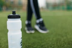Mädchen nach Übung, Trinkwasser auf dem Fußballplatz Porträt des schönen Mädchens in der Sportkleidung lizenzfreie stockbilder Mädchen nach Übung, Trinkwasser auf dem Fußballplatz Porträt des schönen Mädchens in der Sportkleidung lizenzfreie stockbilder