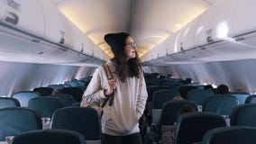 Mädchen sucht nach ihrem Sitz im Flugzeug stock video footage Mädchen sucht nach ihrem Sitz im Flugzeug stock video footage