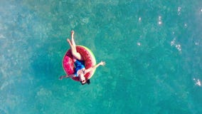 Mädchenflöße in einem Pool auf einem Gummiring stock video footage Mädchenflöße in einem Pool auf einem Gummiring stock video footage