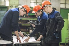 Männer mit den Zeichnungen, die in einer alten Fabrik arbeiten, um das Ausrüstung zu installieren stockbilder Männer mit den Zeichnungen, die in einer alten Fabrik arbeiten, um das Ausrüstung zu installieren stockbilder
