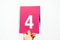 Männliche Hand, die Notizbuch mit großer Nr. 4 auf Magenta hält stockbild Männliche Hand, die Notizbuch mit großer Nr. 4 auf Magenta hält stockbild