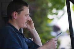 Männlicher Fahrer, der in der Hand durch Handy mit Anmerkungen nennt stockbild Männlicher Fahrer, der in der Hand durch Handy mit Anmerkungen nennt stockbild