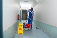 Männlicher Hausmeister Cleaning Floor Lizenzfreies Stockfoto Männlicher Hausmeister Cleaning Floor Lizenzfreies Stockfoto