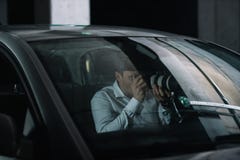 männlicher privater Detektiv, der Überwachung durch Kamera mit Gegenstandglas von tut stockbild männlicher privater Detektiv, der Überwachung durch Kamera mit Gegenstandglas von tut stockbild