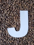 märka J i vit och bakgrund med grillade kaffebönor, bakgrund och textur royaltyfria bilder märka J i vit och bakgrund med grillade kaffebönor, bakgrund och textur royaltyfria bilder
