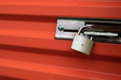 Mässingshänglås på orange metalldörr royaltyfria foton Mässingshänglås på orange metalldörr royaltyfria foton