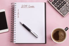 2019 mål listar med anteckningsboken, kopp kaffe över på rosa bakgrund royaltyfria bilder 2019 mål listar med anteckningsboken, kopp kaffe över på rosa bakgrund royaltyfria bilder
