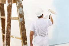 Målareman på arbete med en målarfärgrulle, väggmålning arkivbild Målareman på arbete med en målarfärgrulle, väggmålning arkivbild