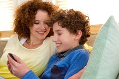 Mère de sourire s'asseyant à la maison avec son fils photos stock Mère de sourire s'asseyant à la maison avec son fils photos stock
