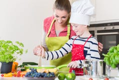 Mère et fils faisant cuire le dîner de famille ensemble images stock Mère et fils faisant cuire le dîner de famille ensemble images stock