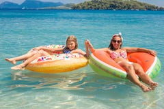 Mère heureuse appréciant l'été avec sa fille en mer photographie stock libre de droits Mère heureuse appréciant l'été avec sa fille en mer photographie stock libre de droits