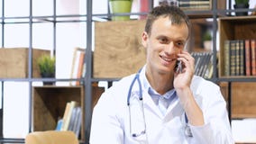 Médecin mûr beau consultant le patient sur le smartphone images libres de droits Médecin mûr beau consultant le patient sur le smartphone images libres de droits
