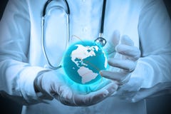 Médecin tenant un gobe du monde dans des ses mains image stock Médecin tenant un gobe du monde dans des ses mains image stock
