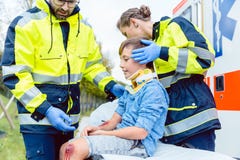 Médecins de secours prenant soin de garçon blessé photos libres de droits Médecins de secours prenant soin de garçon blessé photos libres de droits