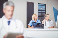 Médecins féminins avec le rayon X tout en travaillant au bureau d'ordinateur image libre de droits Médecins féminins avec le rayon X tout en travaillant au bureau d'ordinateur image libre de droits