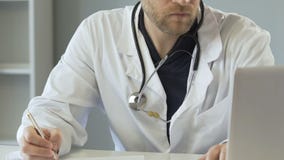 Médico profissional que enche o seguro médico, datilografando no laptop video estoque Médico profissional que enche o seguro médico, datilografando no laptop video estoque