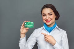 Métier professionnel Position d'hôtesse d'isolement sur le pointage gris au sourire de carte de débit gai photographie stock Métier professionnel Position d'hôtesse d'isolement sur le pointage gris au sourire de carte de débit gai photographie stock