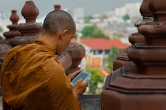 Mönch, der Smarttelefon betrachtet lizenzfreie stockfotografie Mönch, der Smarttelefon betrachtet lizenzfreie stockfotografie
