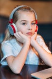 Música de escuta da menina pensativa nos fones de ouvido foto de stock Música de escuta da menina pensativa nos fones de ouvido foto de stock