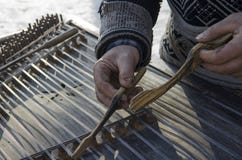 Músico sucio de la calle de las manos el viejo jugó en un instrumento musical viejo fotografía de archivo libre de regalías Músico sucio de la calle de las manos el viejo jugó en un instrumento musical viejo fotografía de archivo libre de regalías